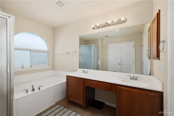 a spacious bathroom with a bathtub sink and mirror