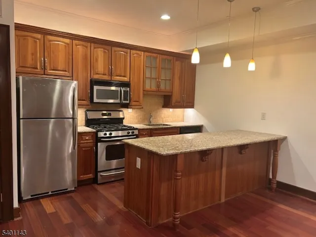 a kitchen with kitchen island a counter space a sink appliances and cabinets