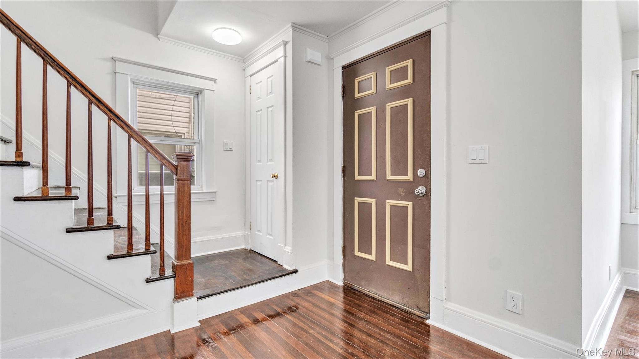 3 Walnut Place Great Neck, NY 11021 - Photo 8 of 34 Front entrance with dark wood finished floors, stairway, and ornamental molding