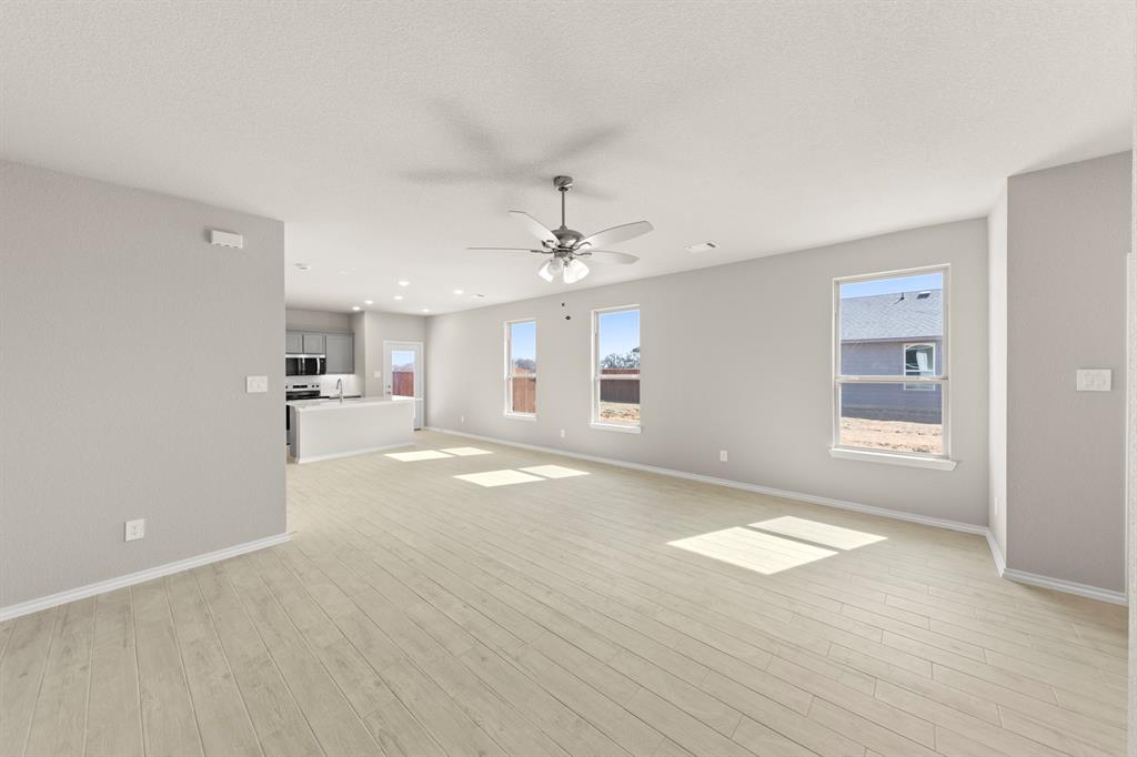 8224 Kingfisher Road Pilot Point, TX 76258 - Photo 11 of 27 wooden floor in an empty room with a kitchen