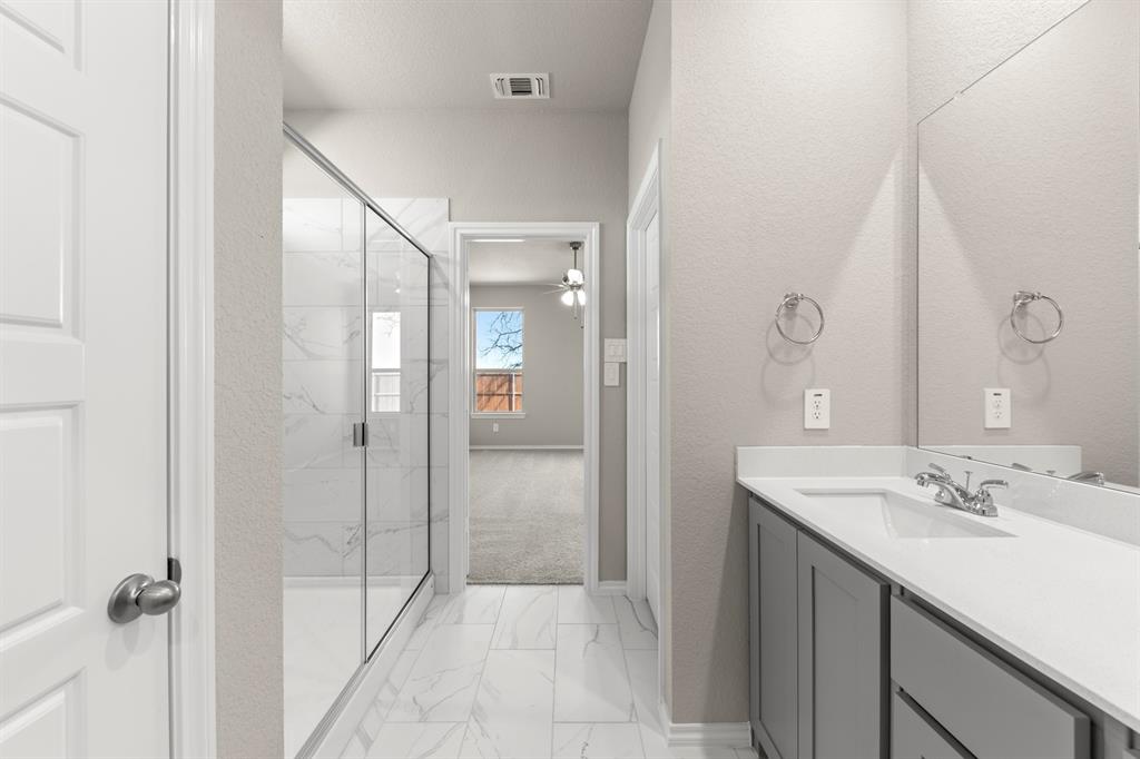 8224 Kingfisher Road Pilot Point, TX 76258 - Photo 23 of 27 a bathroom with a shower sink and mirror