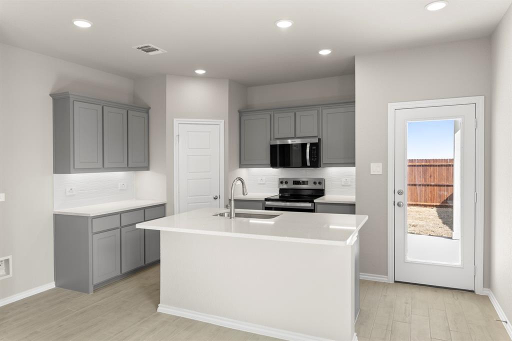 8224 Kingfisher Road Pilot Point, TX 76258 - Photo 5 of 27 a kitchen with microwave a sink and cabinets