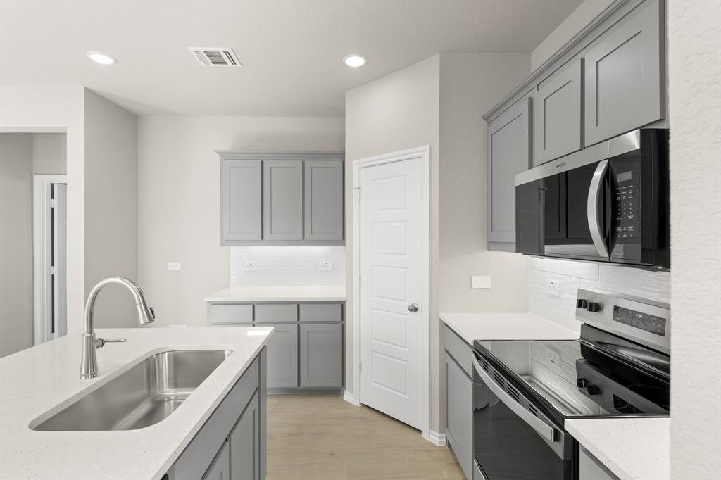 8224 Kingfisher Road Pilot Point, TX 76258 - Photo 6 of 27 a kitchen with stainless steel appliances a sink a stove and cabinets