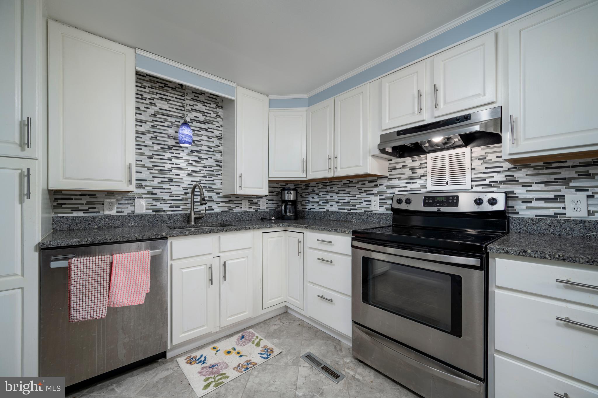 69 Windjammer Road Ocean Pines, MD 21811 - Photo 11 of 53 a kitchen with granite countertop white cabinets stainless steel appliances and a sink