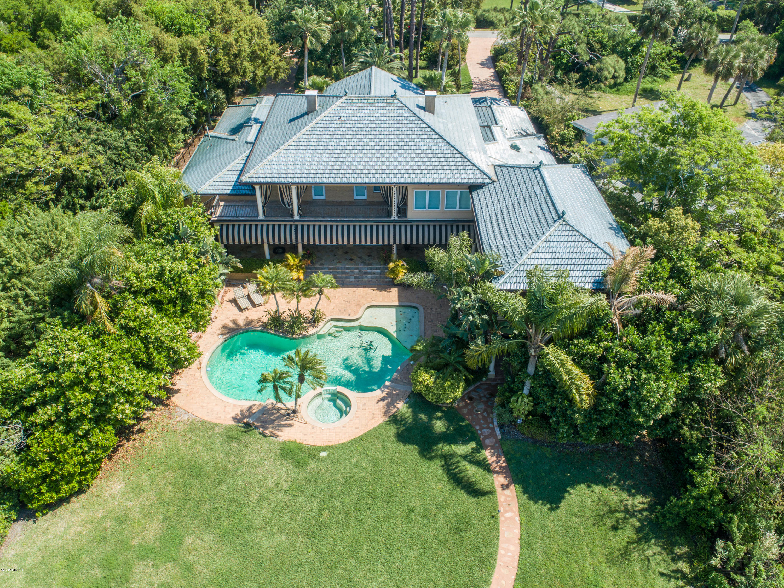 a aerial view of a house with table and chairs plants and large trees