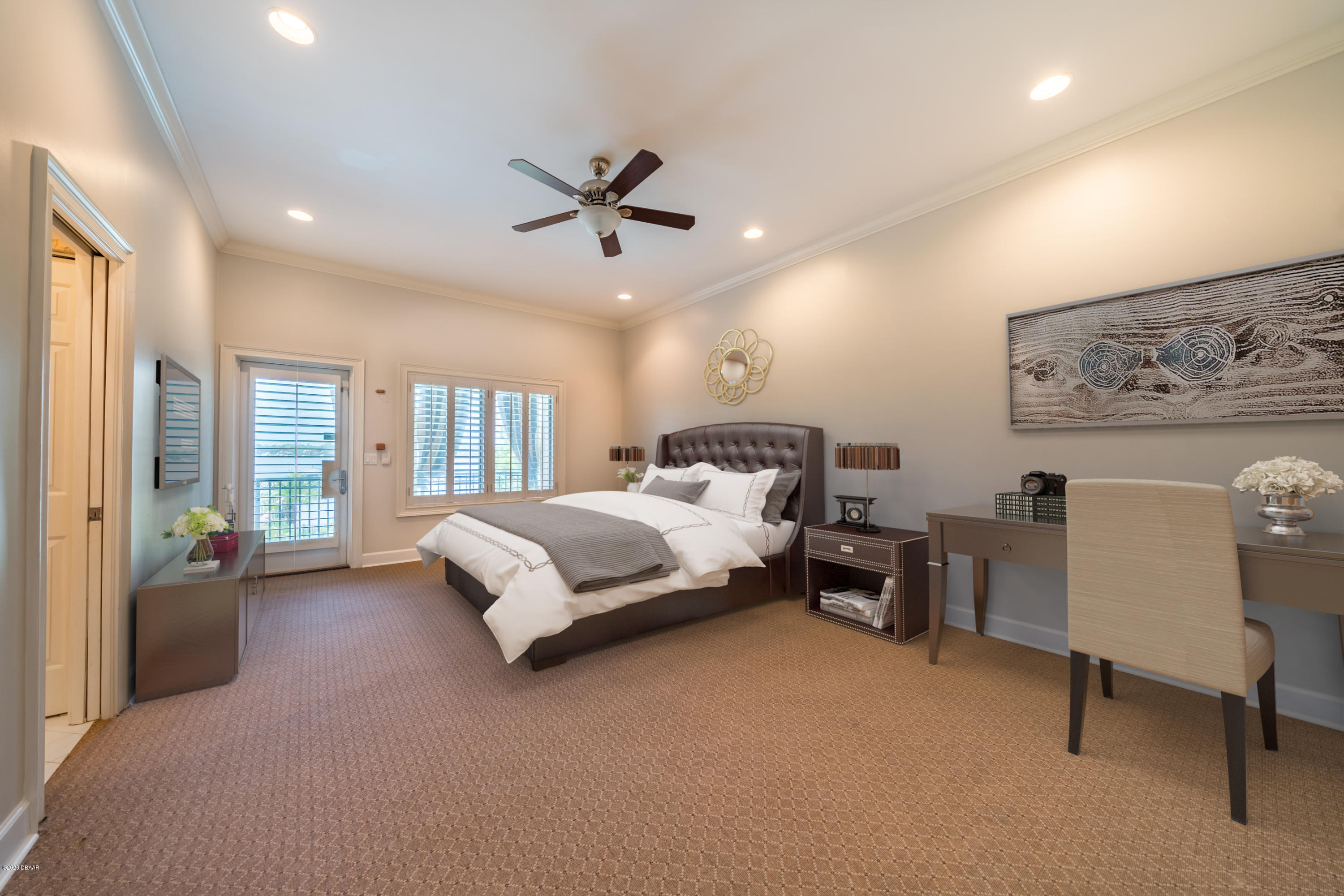 300 Riverside Drive Ormond Beach, FL 32176 - Photo 24 of 72 a spacious bedroom with a bed and a chandelier