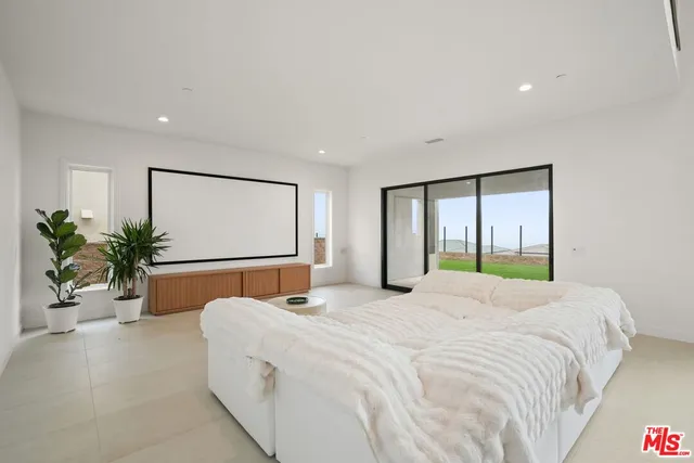 a bedroom with a large bed and potted plant