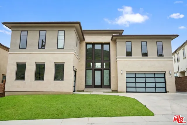 a front view of a house with a garden and yard