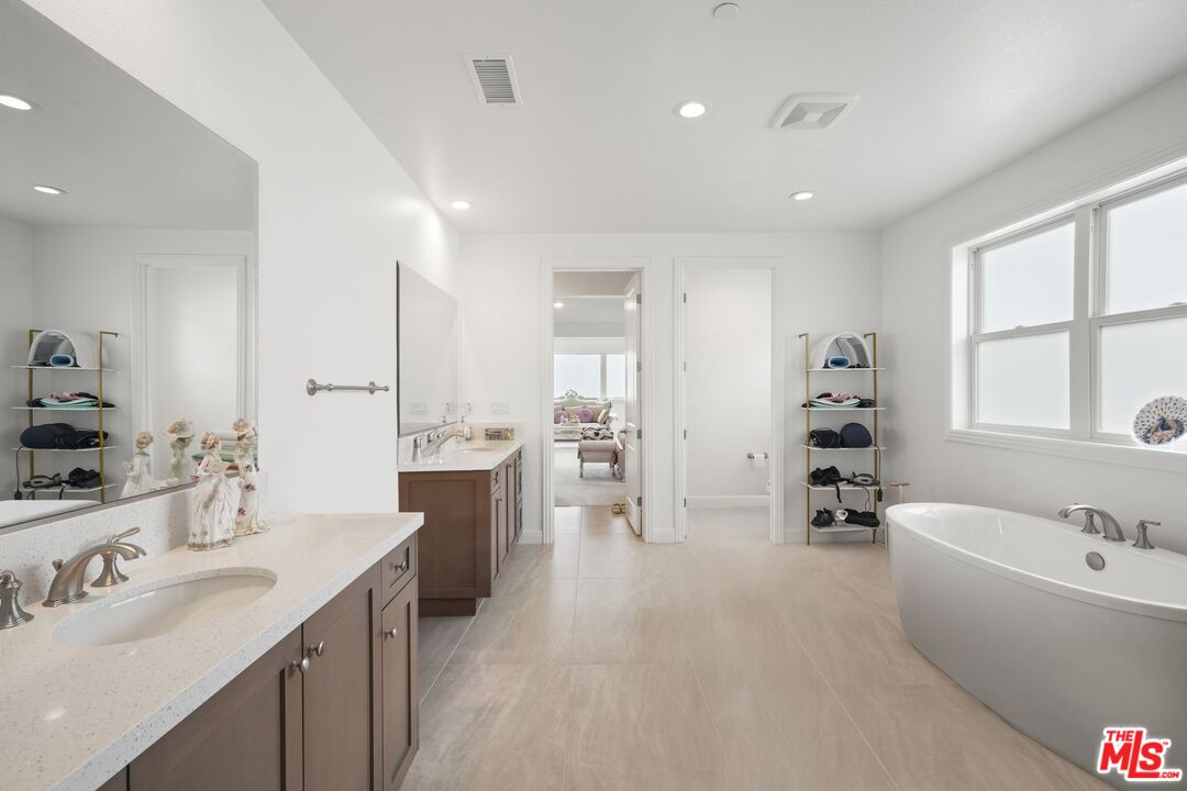 20244 Albion Way Porter Ranch, CA 91326 - Photo 25 of 47 a large white bathroom with a tub a sink and a large mirror
