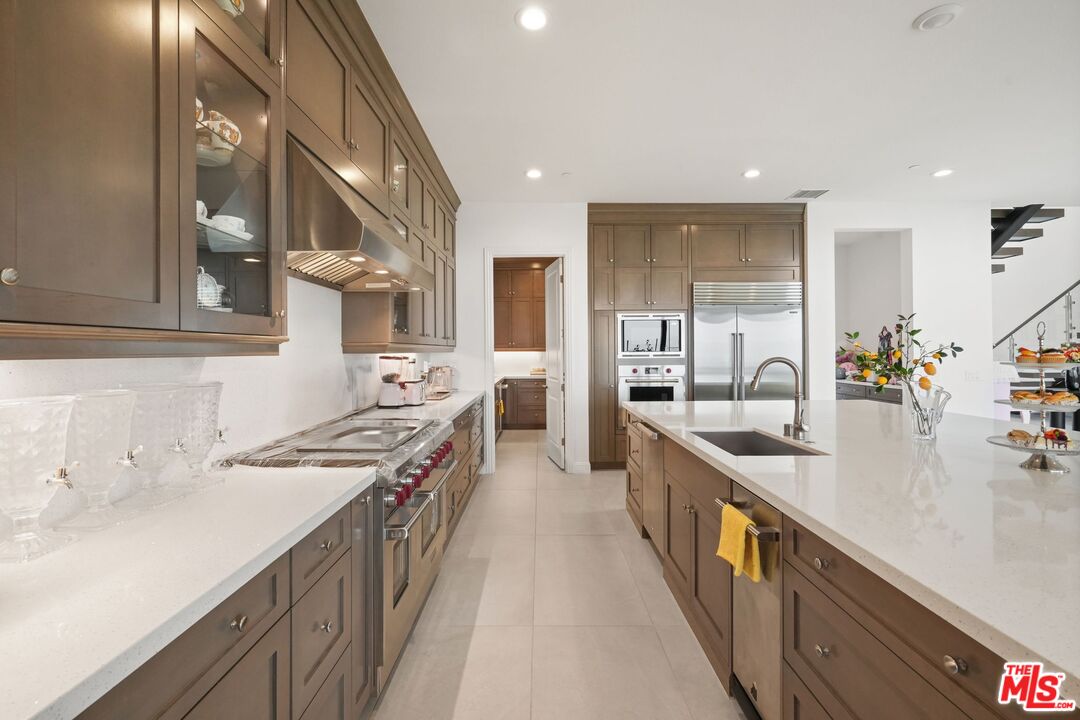20244 Albion Way Porter Ranch, CA 91326 - Photo 9 of 47 a kitchen with stainless steel appliances a sink stove and cabinets