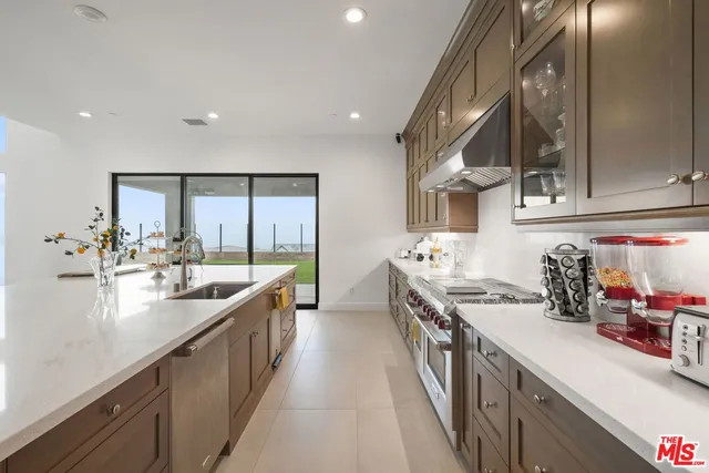 a kitchen with stainless steel appliances a sink stove and cabinets