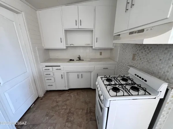 a kitchen with a sink a stove and cabinets