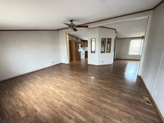 a view of an empty room with window and wooden floor