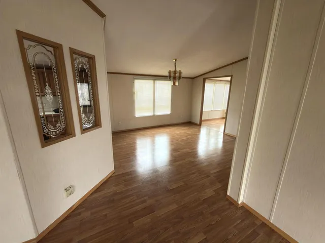 a view of a hallway with wooden floor and stairs