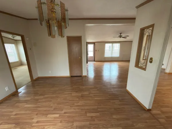 a view of a hallway with wooden floor and staircase