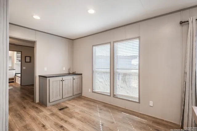 a view of an empty room with window and cabinet