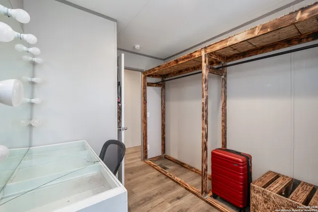 an empty room with wooden floor and white walls