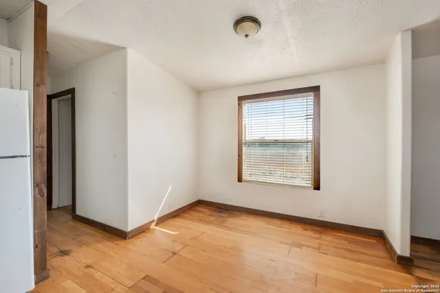 an empty room with fan and entrance