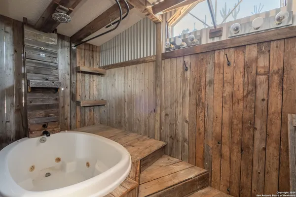 an empty room with wooden floor and a ceiling fan
