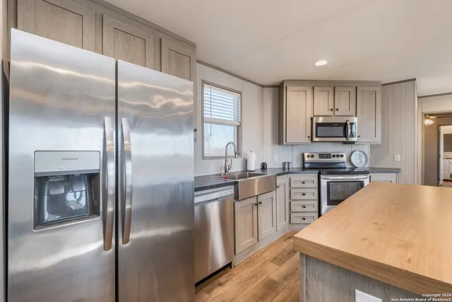 a kitchen with kitchen island a counter top space cabinets and stainless steel appliances