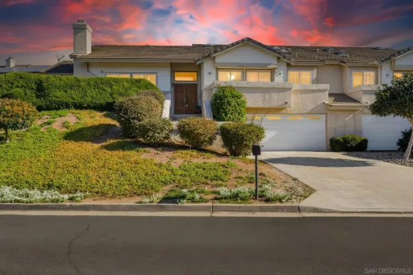 a front view of a house with a yard and potted plants