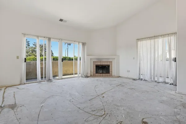 a view of an empty room with a fireplace and a window