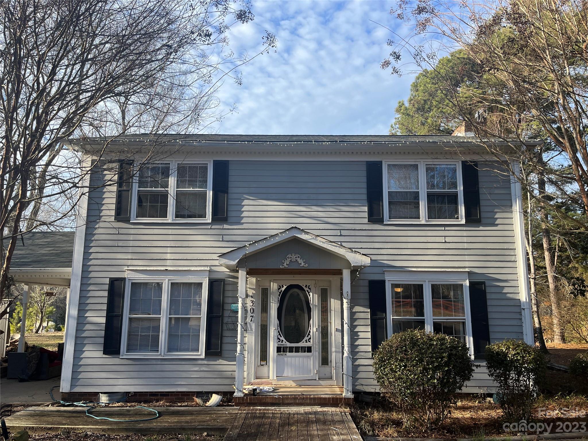 a view of a house with large windows and a tree