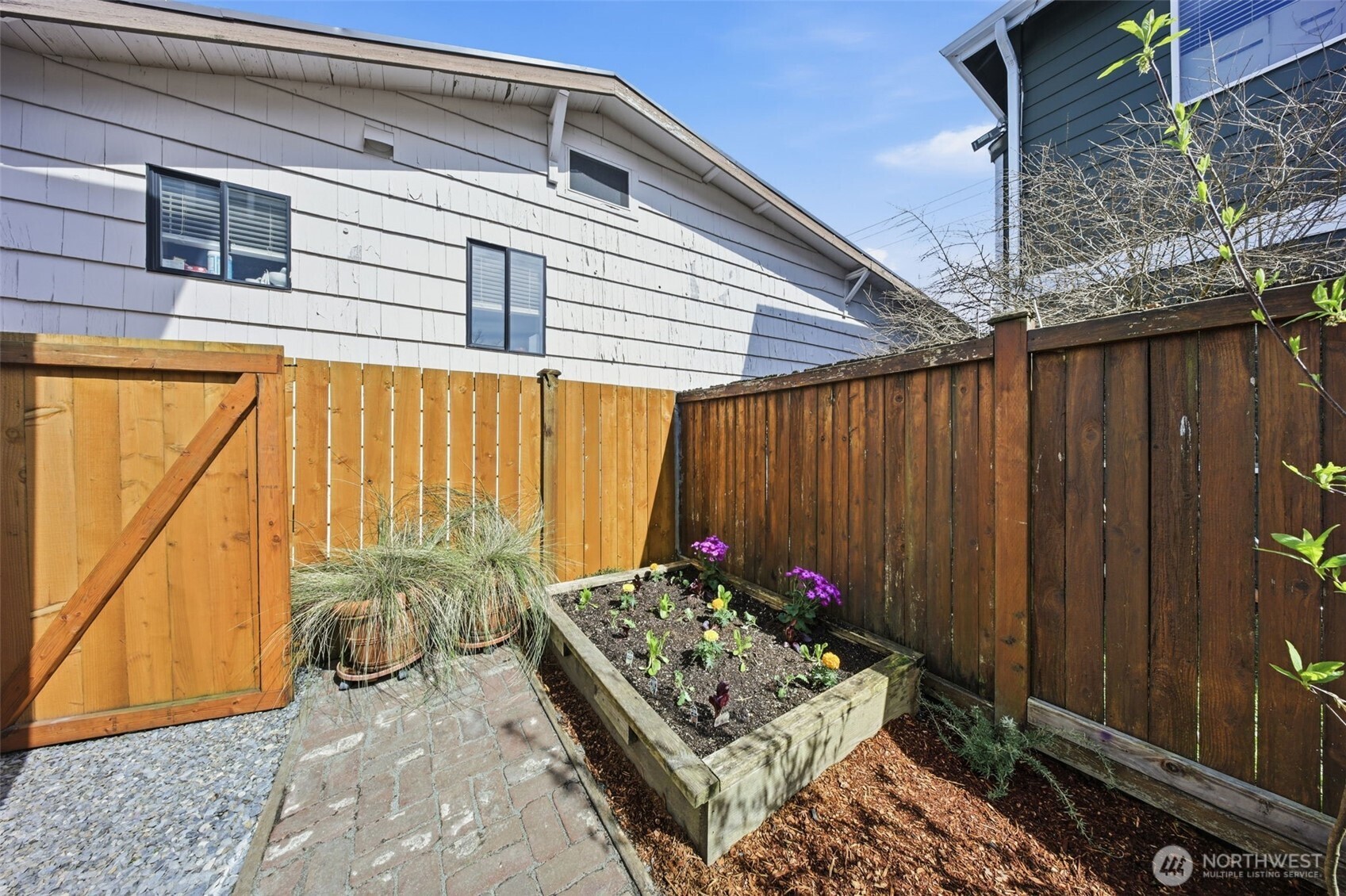 8847 9th Avenue Southwest, Unit A Seattle, WA 98106 - Photo 3 of 31 a view of a backyard with table and chairs and potted plants