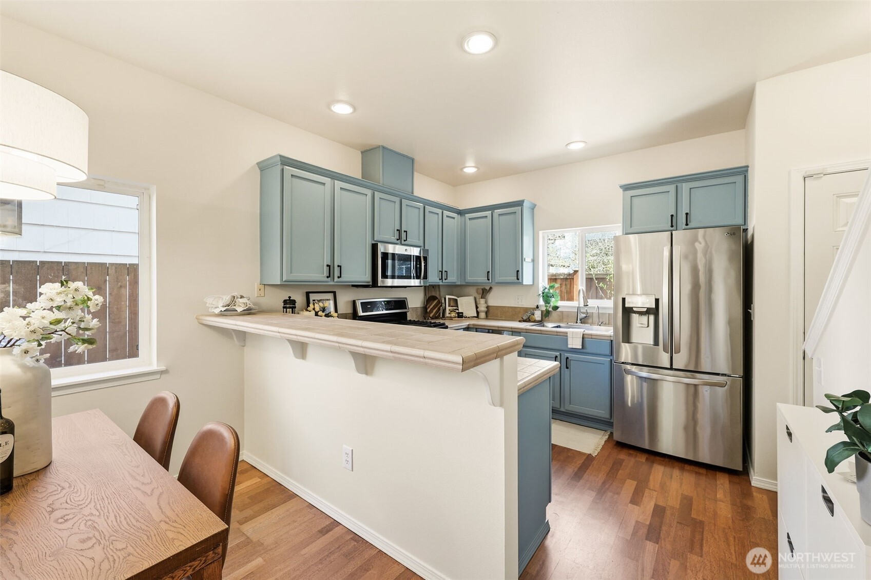 8847 9th Avenue Southwest, Unit A Seattle, WA 98106 - Photo 9 of 31 a kitchen with stainless steel appliances granite countertop a refrigerator a stove a sink dishwasher and a refrigerator with wooden floor