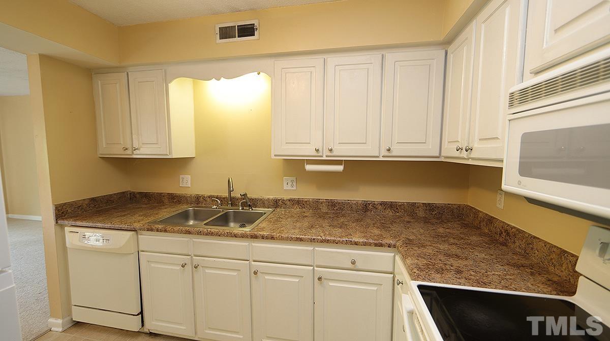 612 Pine Ridge Place, Unit 612 Raleigh, NC 27609 - Photo 3 of 12 a kitchen with granite countertop white cabinets and a sink