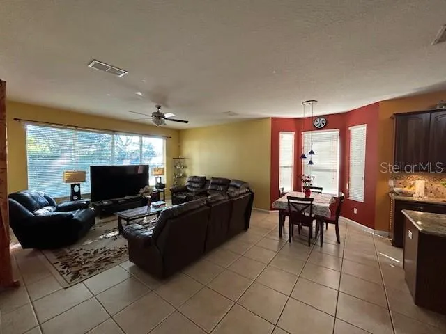 a living room with furniture a flat screen tv and large windows