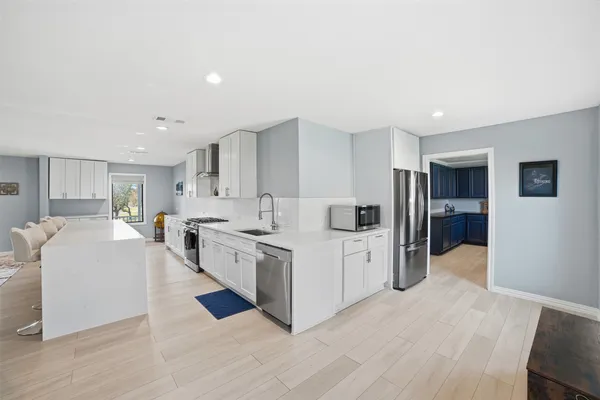a large white kitchen with stainless steel appliances