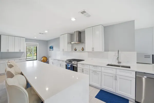a kitchen with stainless steel appliances a white stove top oven sink and cabinets
