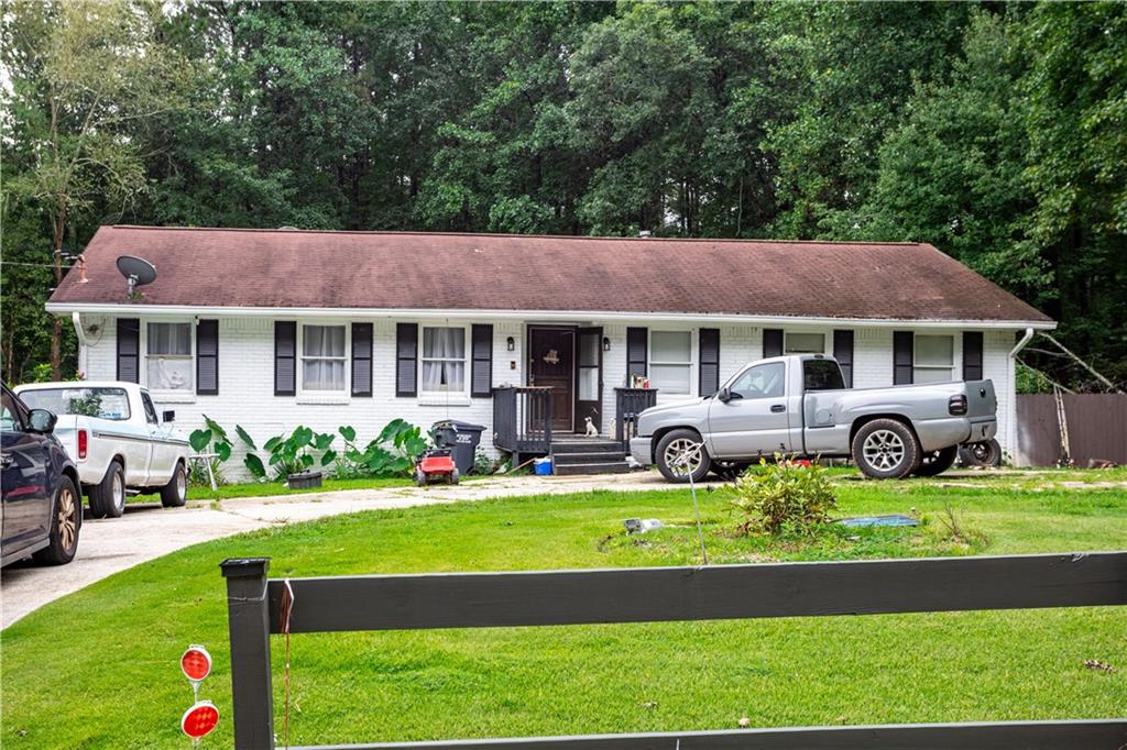 1535 Flat Shoals Road Southwest Conyers, GA 30094 - Photo 1 of 21 a front view of a house with a yard table and chairs