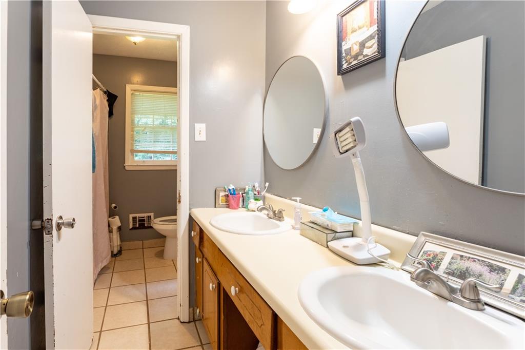 1535 Flat Shoals Road Southwest Conyers, GA 30094 - Photo 15 of 21 a en suite bathroom with a double vanity sink and a mirror
