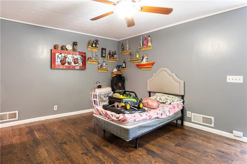 1535 Flat Shoals Road Southwest Conyers, GA 30094 - Photo 7 of 21 a bedroom with furniture and wooden floor