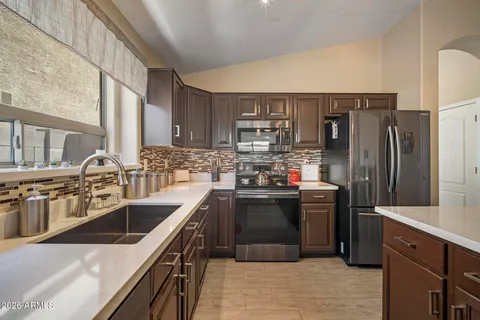 a kitchen with stainless steel appliances granite countertop a sink stove and refrigerator