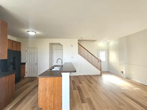 a view of a living room a dining room with wooden floor and a ceiling fan