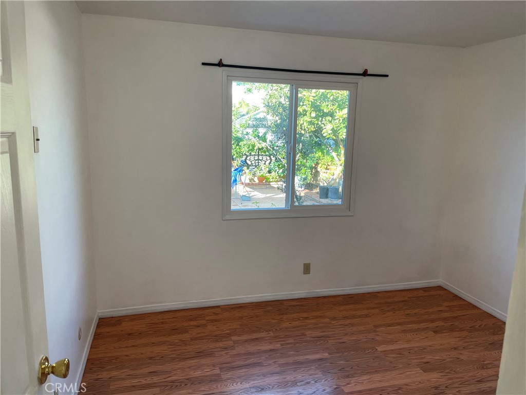825 Sonora Road Costa Mesa, CA 92626 - Photo 19 of 37 a view of an empty room with wooden floor and a window