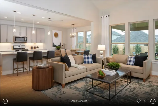 a living room with furniture kitchen and a large window