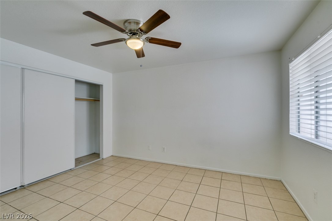 7570 West Flamingo Road, Unit 252 Las Vegas, NV 89147 - Photo 27 of 44 Functional bedroom featuring tile flooring and convenient sliding closet doors for ample storage.