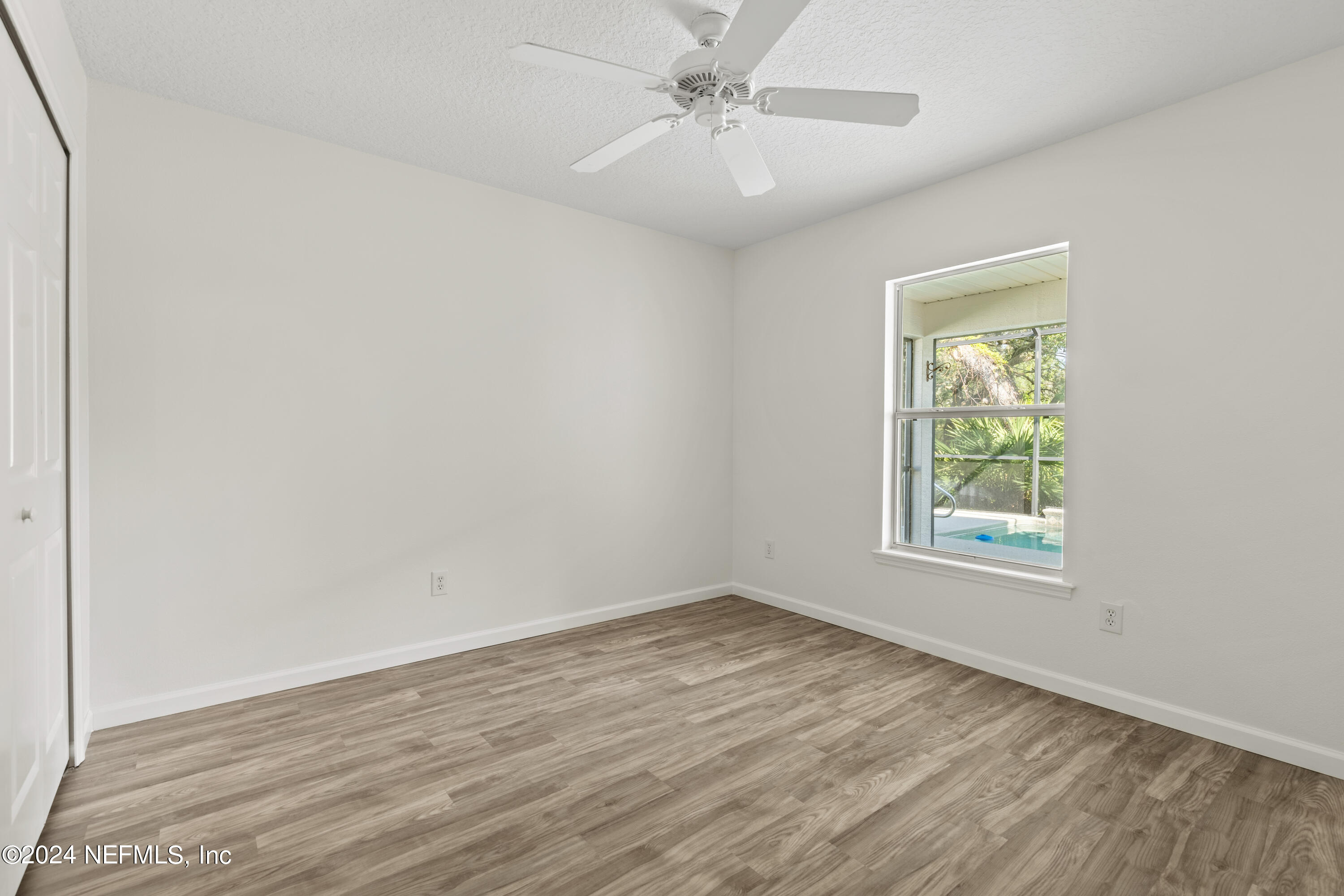 156 Bilbao Drive St. Augustine, FL 32086 - Photo 29 of 57 an empty room with wooden floor ceiling fan and windows