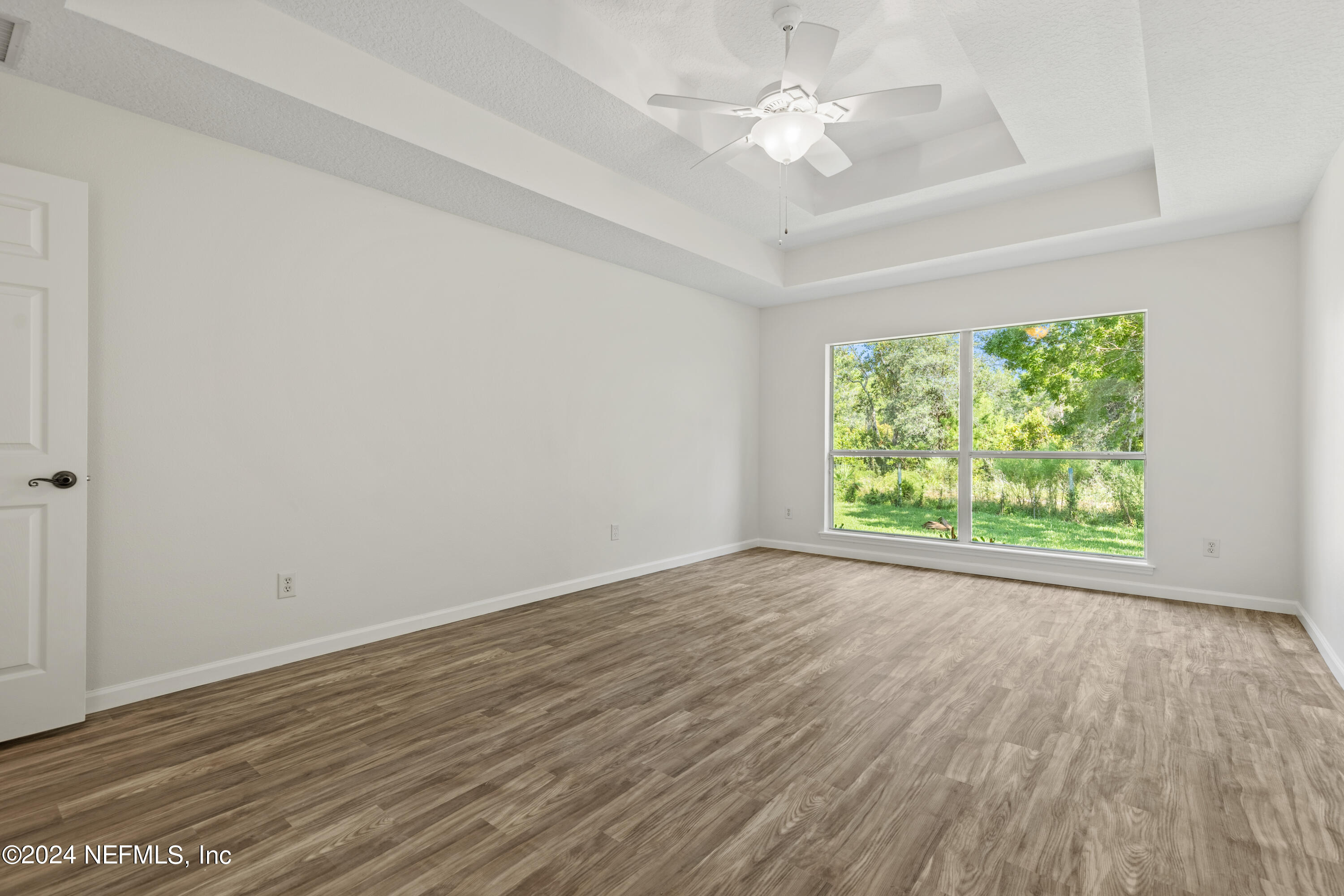 156 Bilbao Drive St. Augustine, FL 32086 - Photo 44 of 57 an empty room with wooden floor and windows