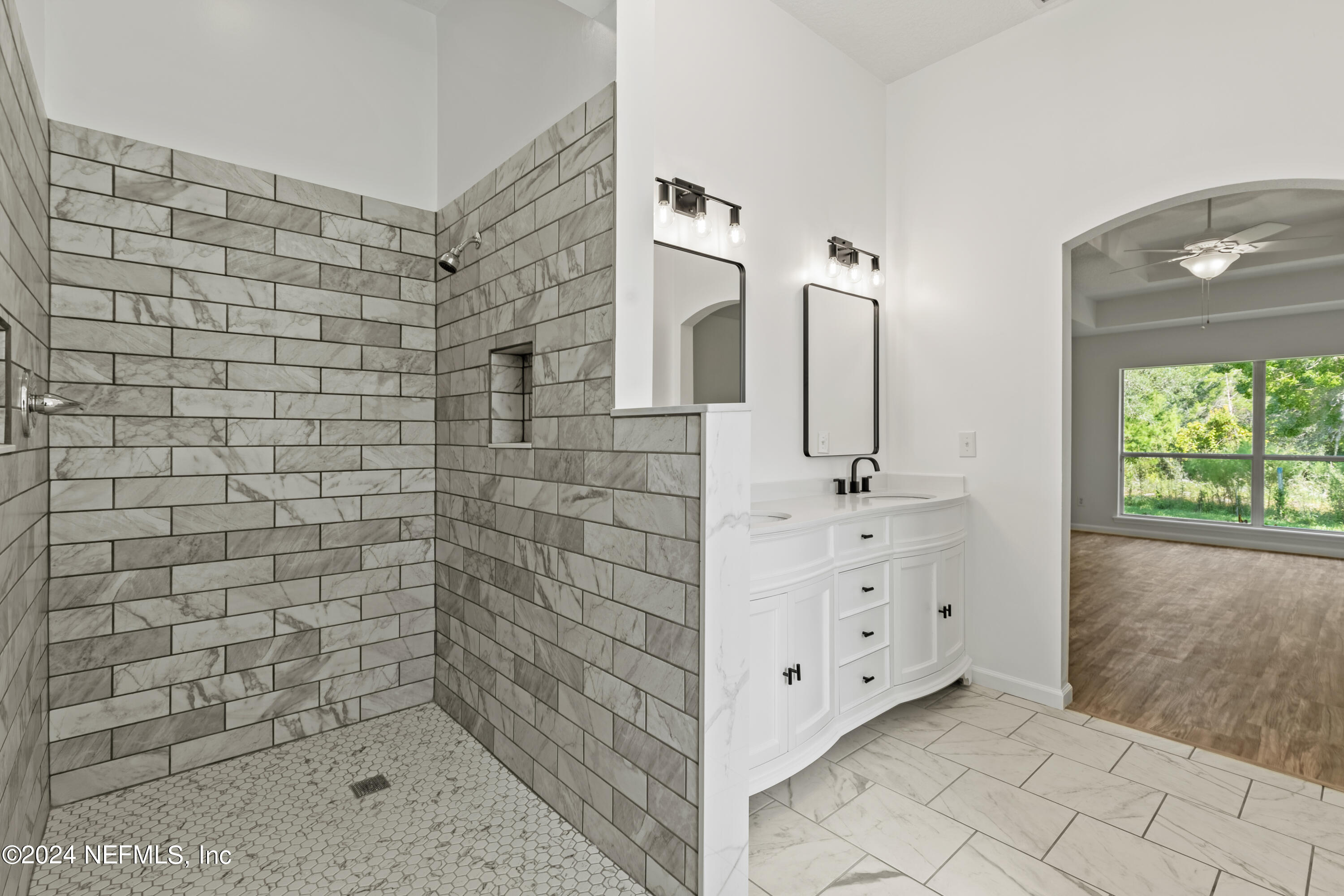 156 Bilbao Drive St. Augustine, FL 32086 - Photo 48 of 57 a bathroom with a double vanity sink a mirror and shower