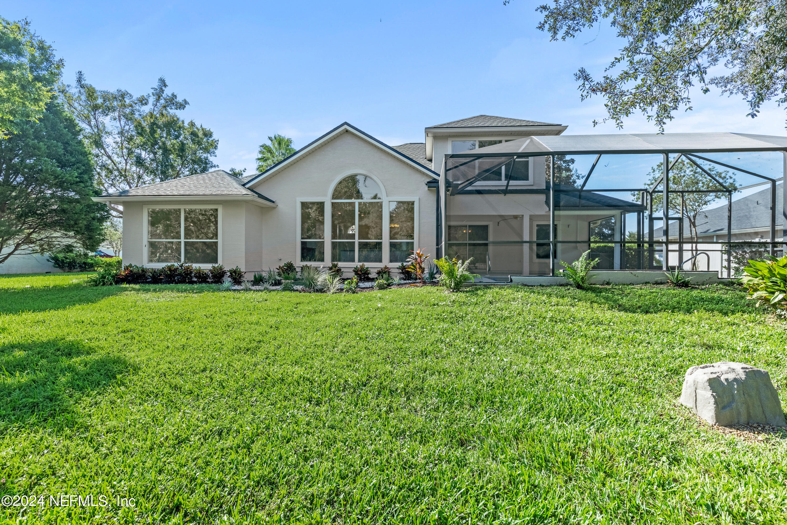 156 Bilbao Drive St. Augustine, FL 32086 - Photo 55 of 57 a front view of a house with a garden and trees