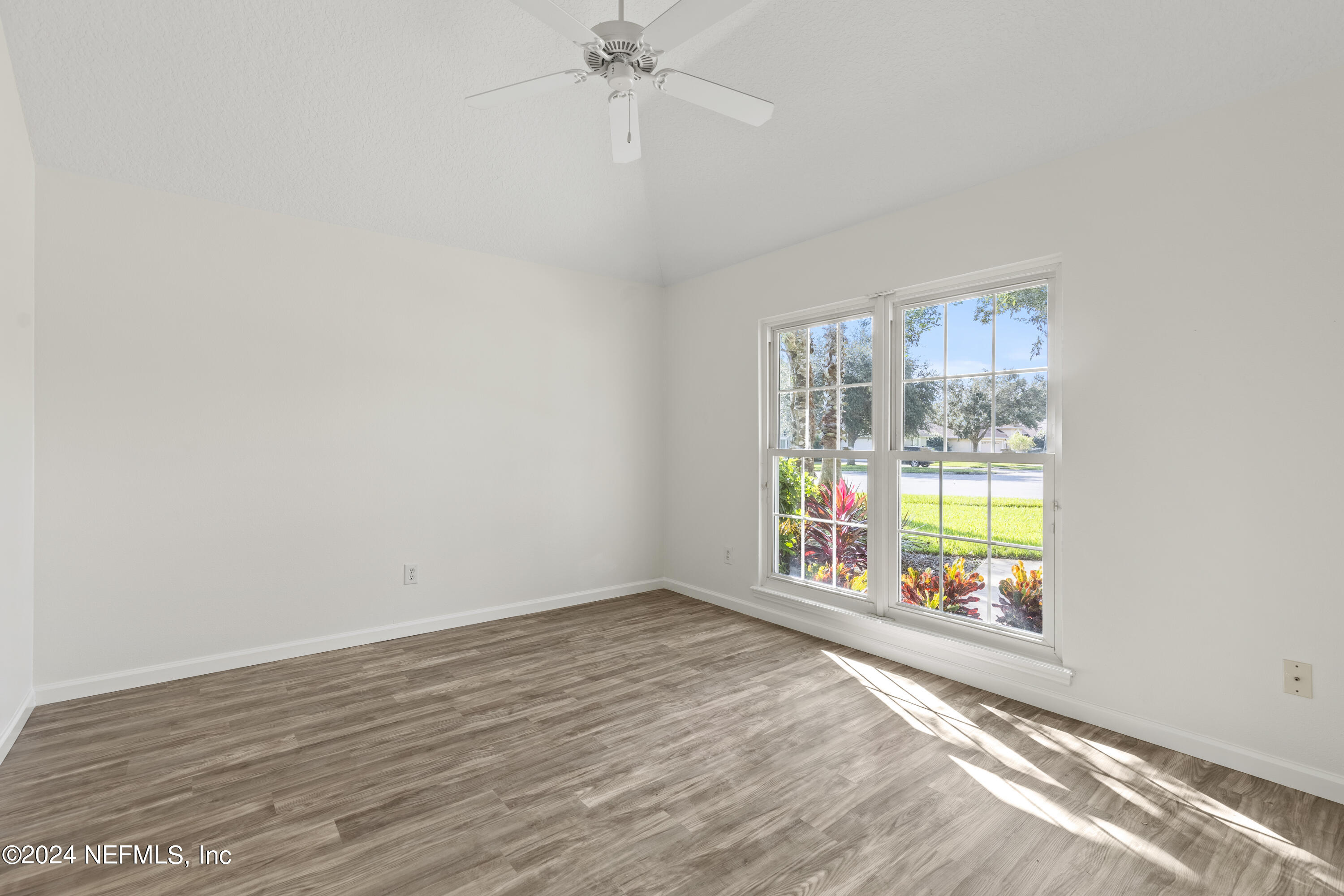 156 Bilbao Drive St. Augustine, FL 32086 - Photo 8 of 57 an empty room with wooden floor fan and windows