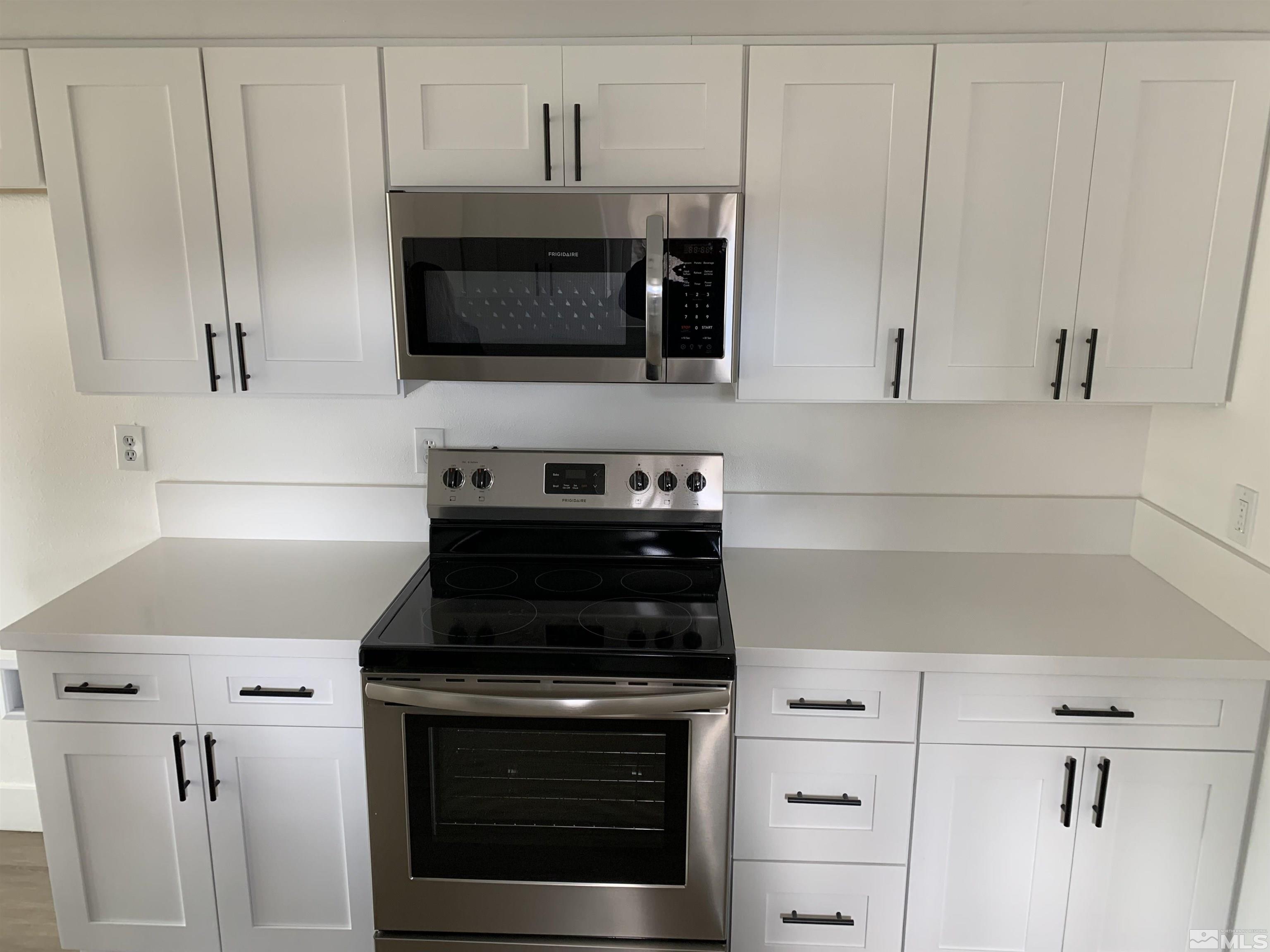 105 Cheyenne Drive Reno, NV 89521 - Photo 3 of 25 a kitchen with white cabinets and black appliances