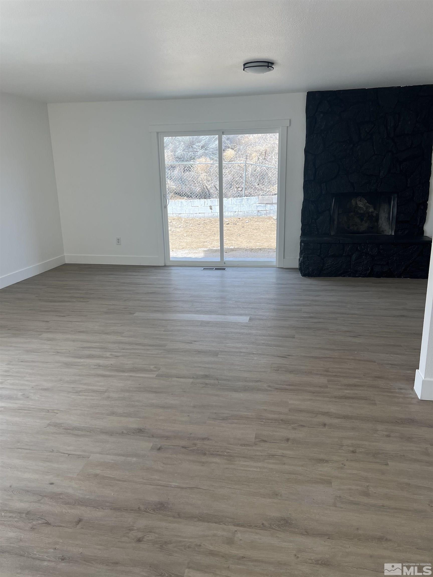 105 Cheyenne Drive Reno, NV 89521 - Photo 6 of 25 a view of an empty room with a window and wooden floor