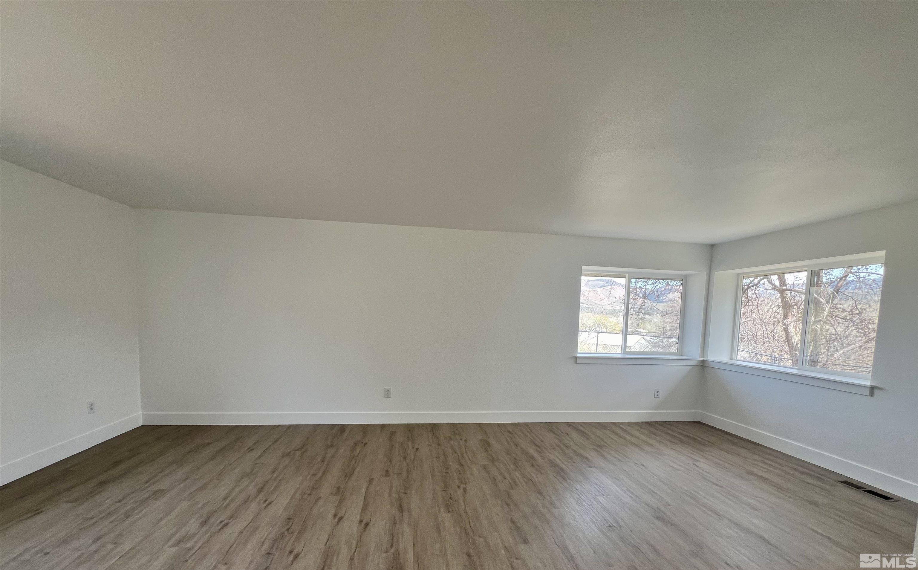 105 Cheyenne Drive Reno, NV 89521 - Photo 8 of 25 an empty room with wooden floor and windows