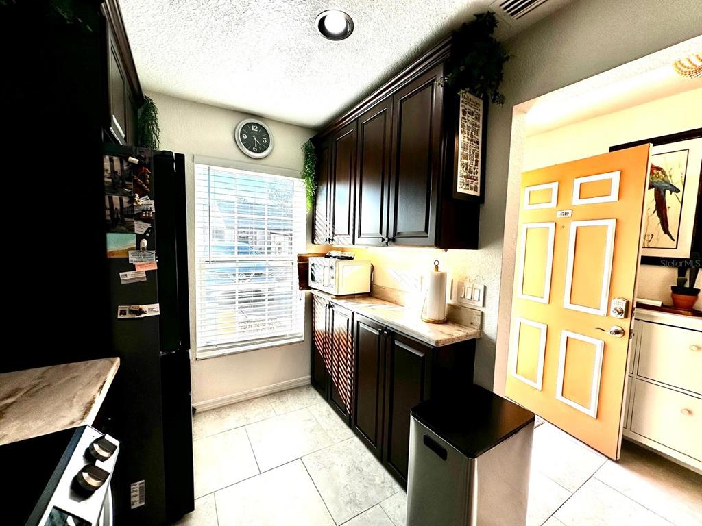 4749 Sunny Loop, Unit 4749 Holiday, FL 34690 - Photo 11 of 34 a kitchen with stainless steel appliances granite countertop a sink stove and refrigerator